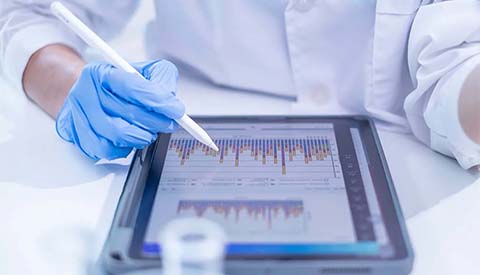 Scientist looking at graphs on a tablet.