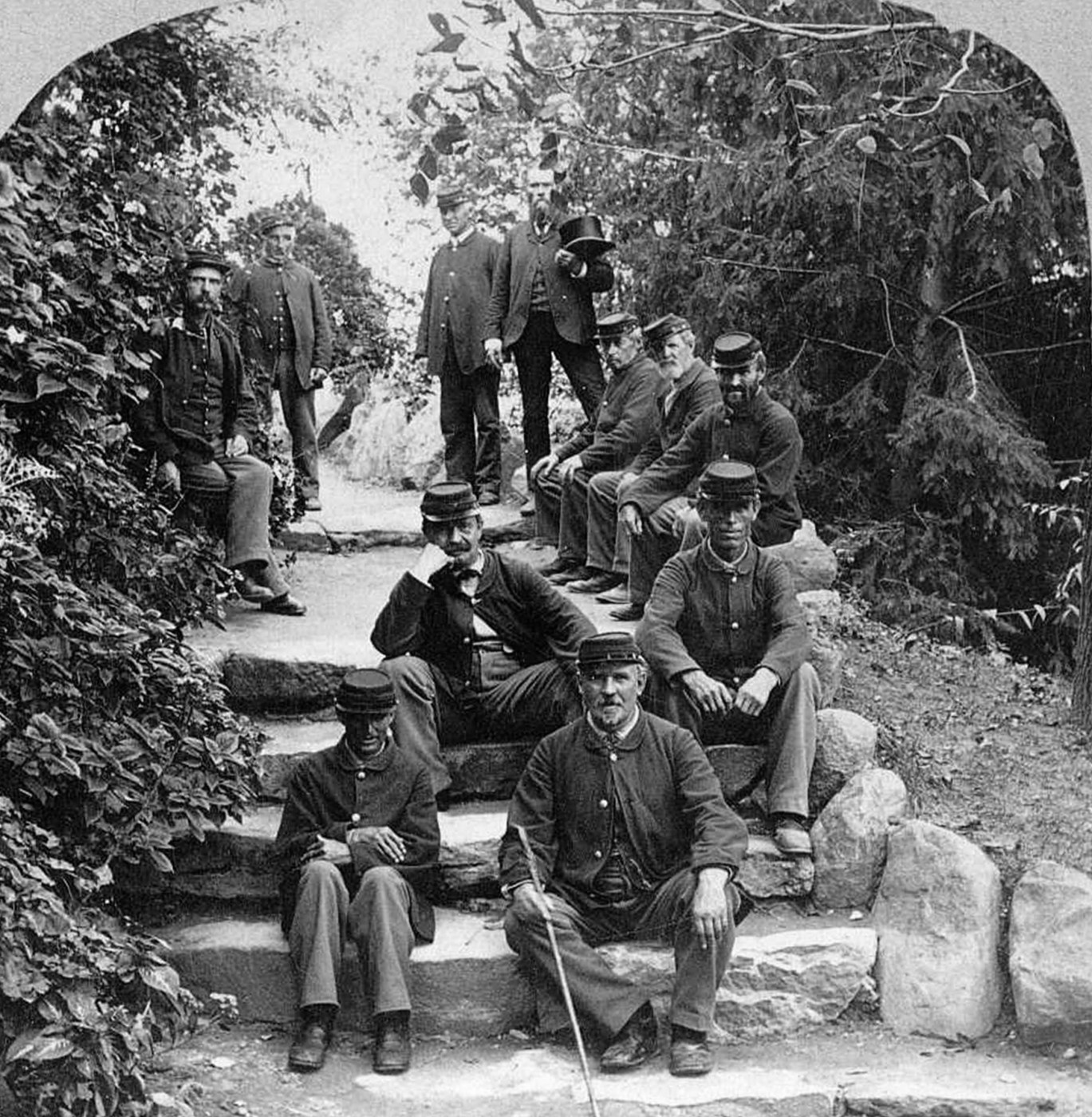 Veteran residents in military uniform pose amid the greenery on the stone steps of the grotto, one of the most popular attractions at the Central Branch of the National Home. (Dayton VAMC)