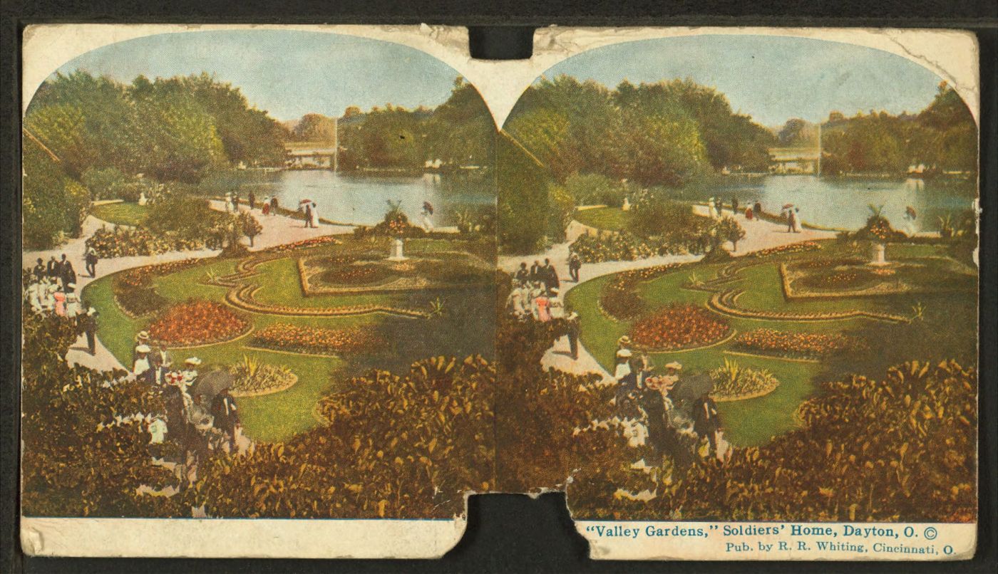 Stereograph from 1902 showing visitors strolling past the decorative gardens and lake at the Dayton, Ohio, Branch of the National Home for Disabled Volunteer Soldiers. The notches at top and bottom were for inserting the images in a stereoscope for three-dimensional viewing. (New York Public Library)