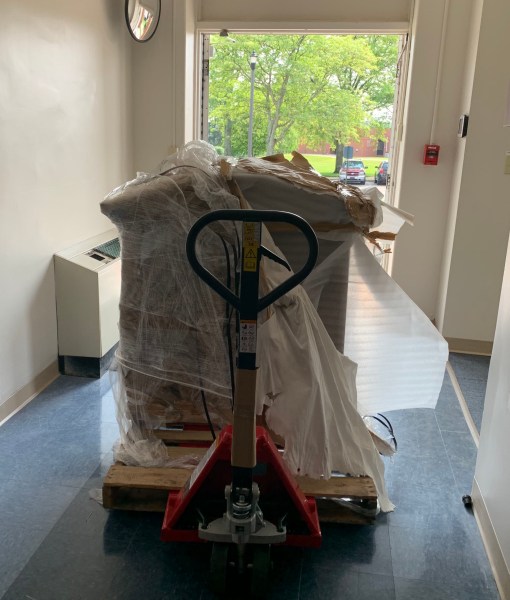 Items from the collection that were being stored in Building 401 wrapped for movement to their new home, Building 126. Many of the older items are heavy, so significant effort was made to move one item at a time. (NVAHC)