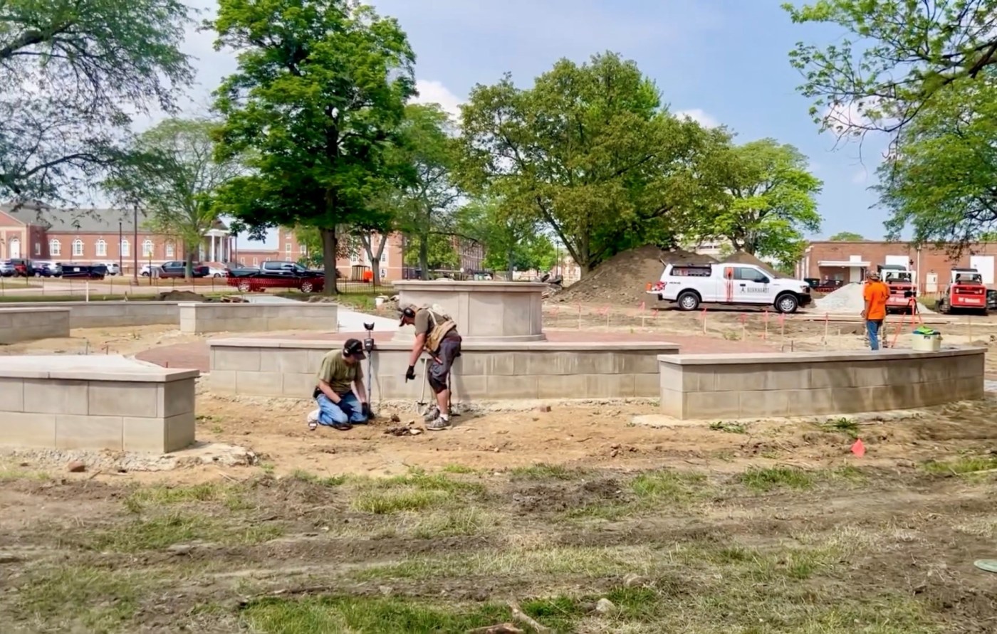 Digging by statue.