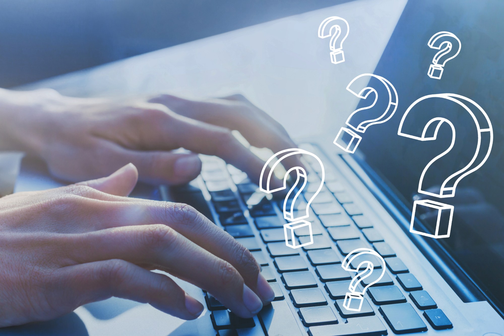 A person's hands on a laptop with floating question marks.