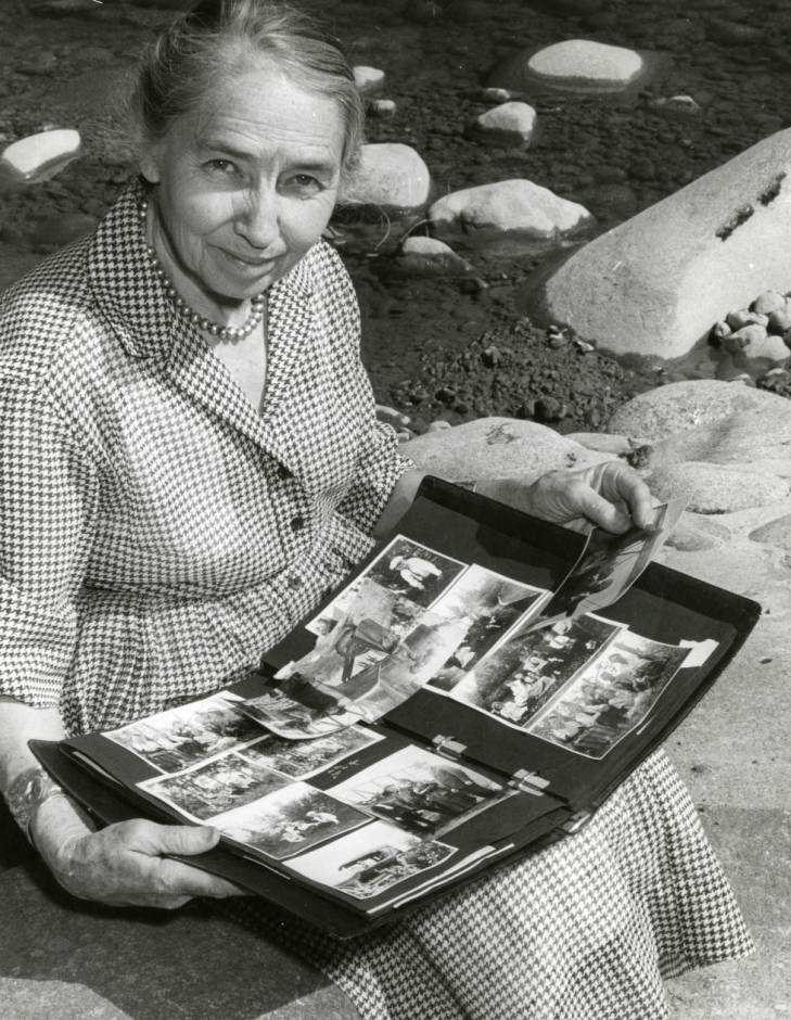 Stinson looking at an old photo album, undated. (University of New Mexico Digital Collections)