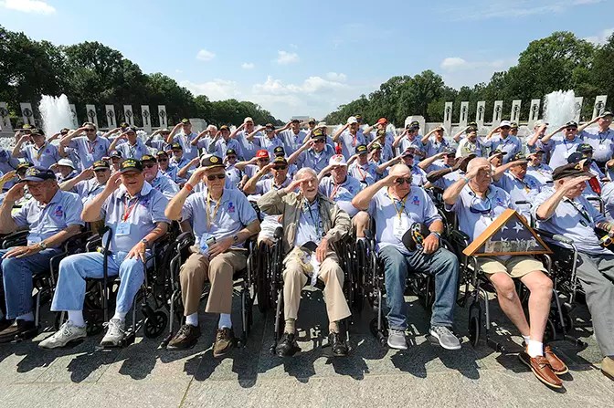 World War Two veterans saluting infront of world war two memorial