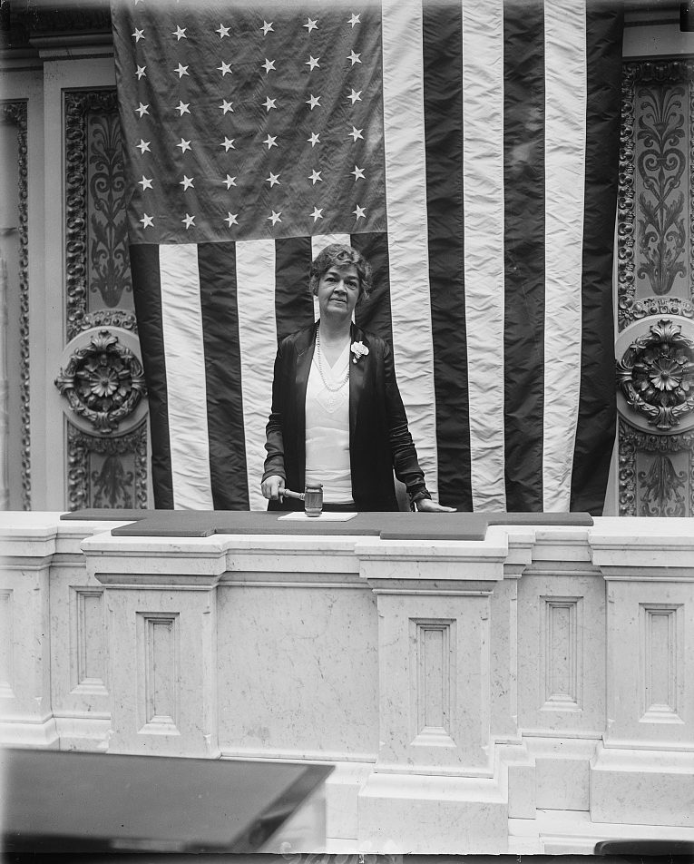 Congresswoman Edith Rogers (R-MA) wielding the speaker’s gavel at a session of the House of Representatives in 1929. Elected in 1925, she served 18 consecutive terms until her death in 1960. Behind her is a large U.S. flag hanging down. (Library of Congress)