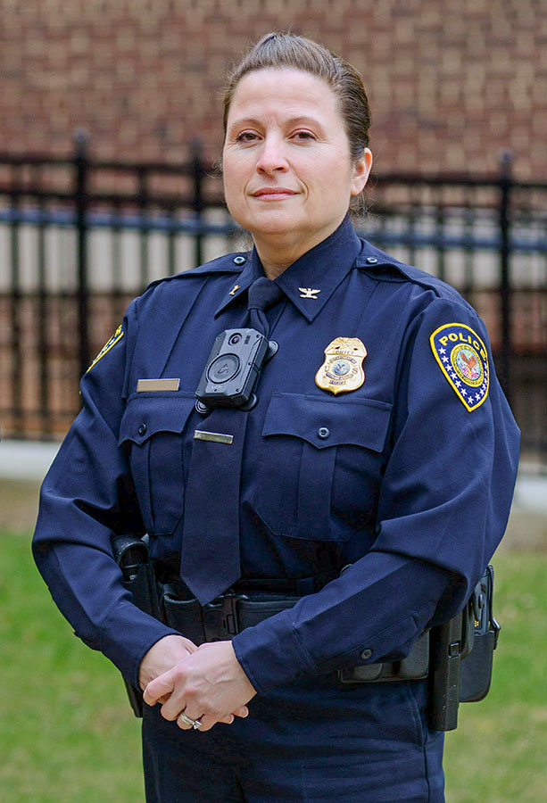 Female VA Police Officer in uniform standing in front of a VA facility